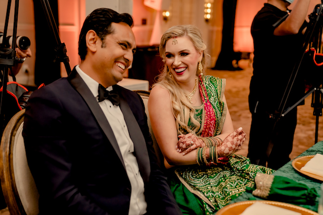 Bride and groom laughing while they sit at the reception at the Hyatt Lost Pines Resort.