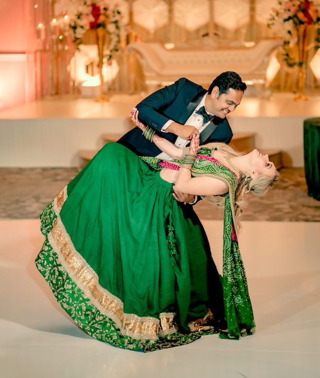 The groom dips the bride as they dance at the wedding reception.