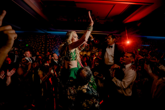 Bride and groom being lifted into the air on the dance floor