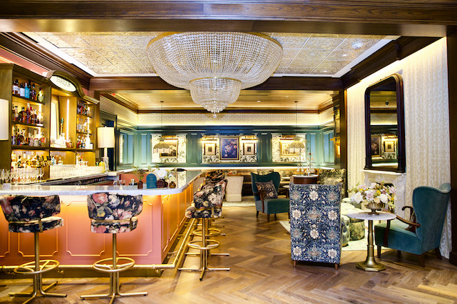 The hideaway bar in the C. Baldwin Hotel with floral chairs and a large chandelier