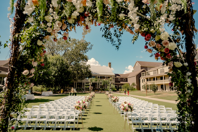 View of the ceremony chairs at the Hyatt Lost Pines Resort under a bloom filled canopy.