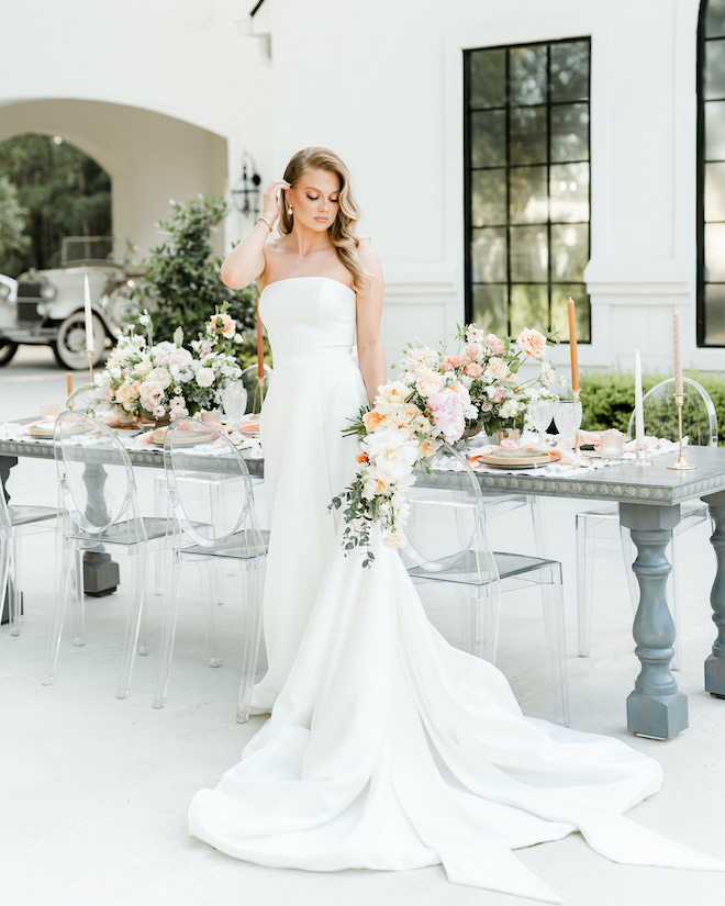 The bride looks down at her shoulder while holding her bouquet outside the wedding venue, The Peach Orchard. 