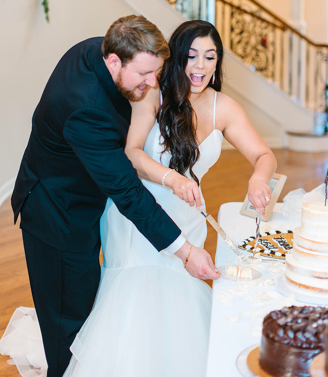 The bride and groom cutting into their wedding cake.