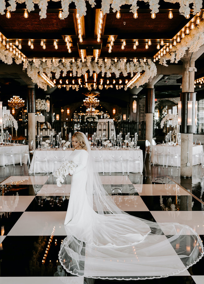 Bride holding a bouquet of lilies wearing a Ines Di Santo white wedding gown during her wedding reception at The Astorian. 