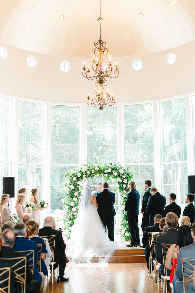 The bride and groom standing at the altar of their traditional ceremony with their loved ones watching. 