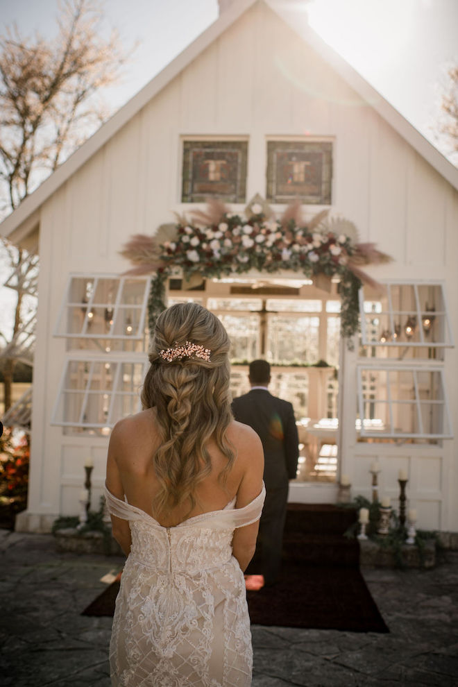 The bride's back right before the groom turns around for the first look in front of the rustic-chic chapel.