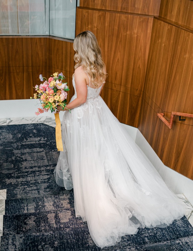 The bride walking down the stairs before her alfresco spring wedding.