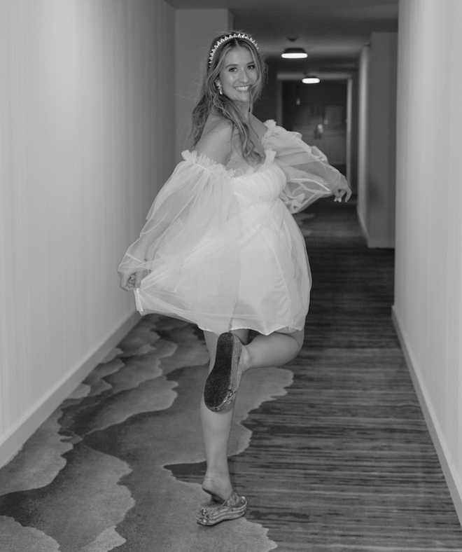 The bride wearing a short white reception dress and pink sandals. 