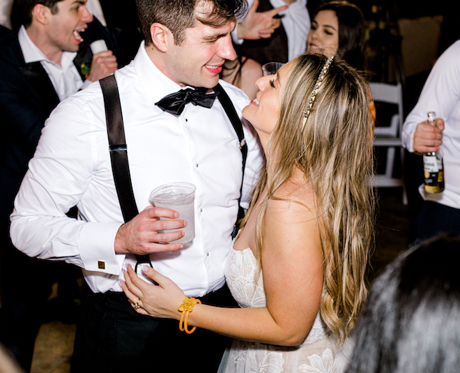 The bride and groom smile at each other during their reception.