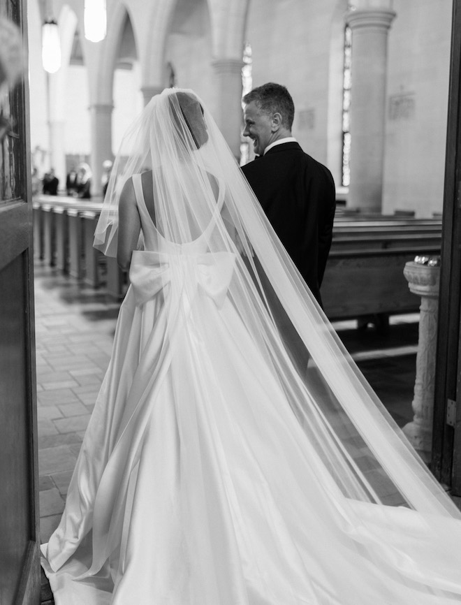 The bride walking down the aisle with her father.