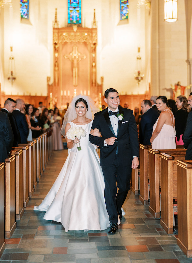 The bride and groom walking down the aisle in the church after their wedding ceremony.