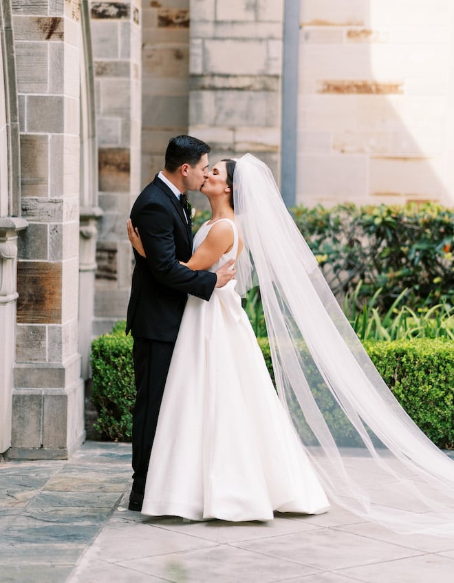 The bride and groom kissing outside of the church.