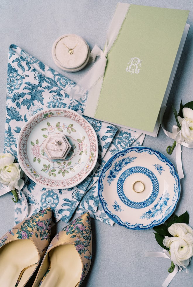 The brides shoes, rings and floral print plates and linens.