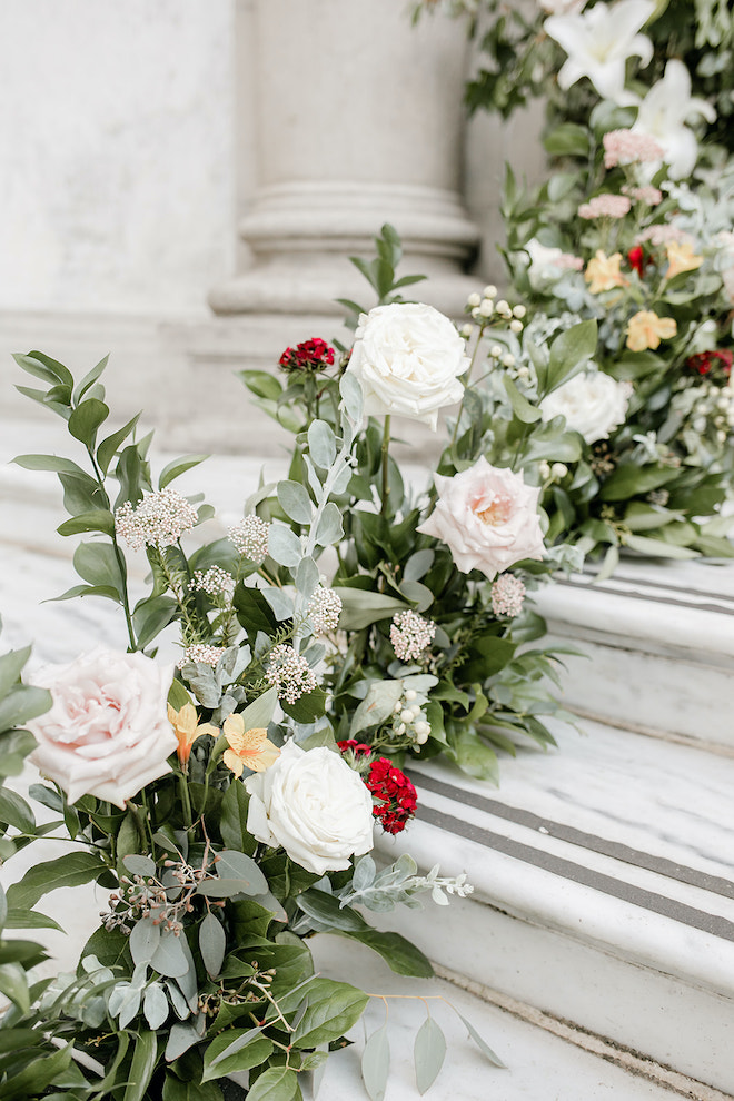 White and blush roses and other florals lining the stairs of the library.