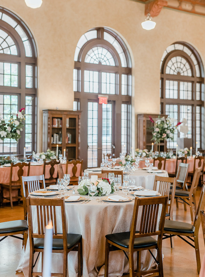 Round reception tables in the library with large windows.