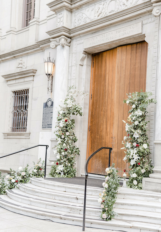 The doors of the Julia Ideson library dripping in florals, before the wedding ceremony begins.