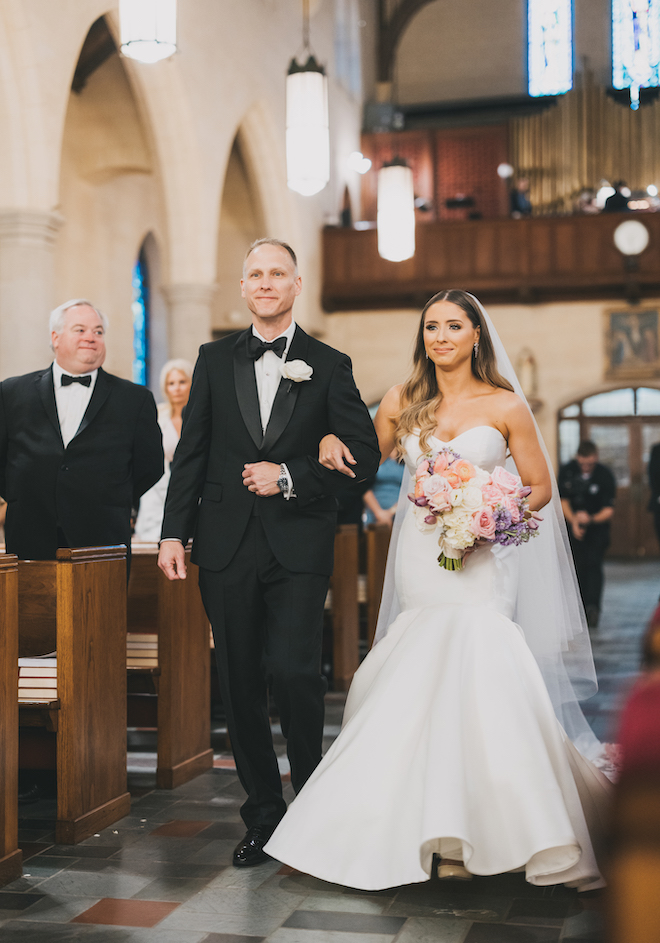 The bride and her father walking down the aisle.