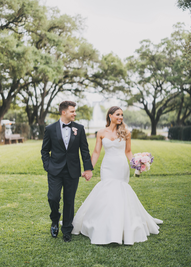 The bride and groom holding hands and walking.