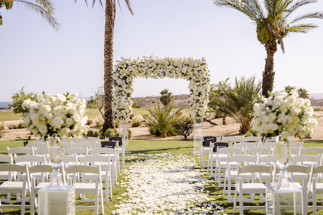 Floral-filled altar for a tropical destination wedding in Los Cabos.