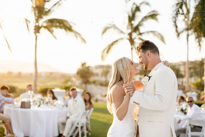 The bride and groom smiling at each other during their first dance.