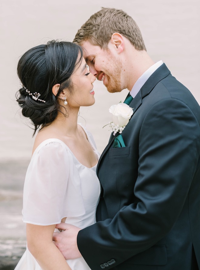 The bride and groom smiling at their romantic white and forest green wedding.