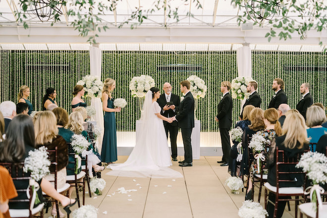 The bride and groom holding hands at their wedding ceremony.