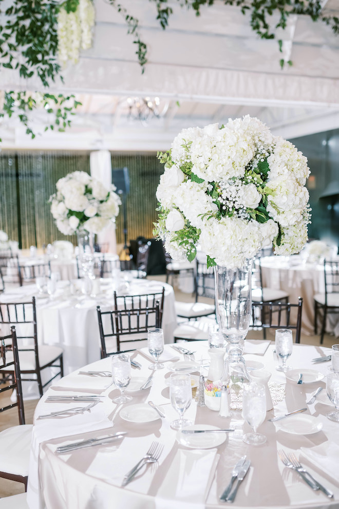 White and forest green bouquet placed on the reception table.