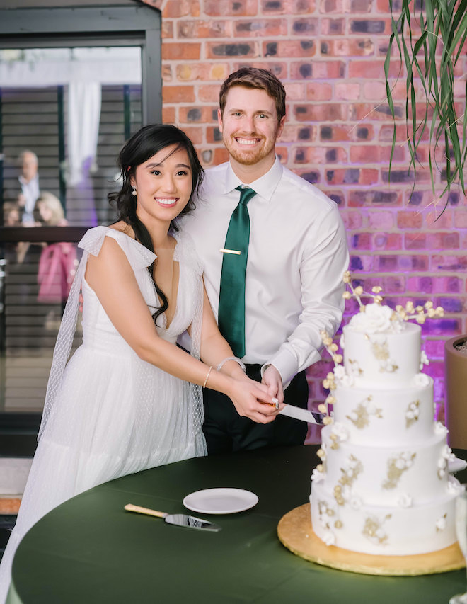 The bride and groom cutting their wedding cake.