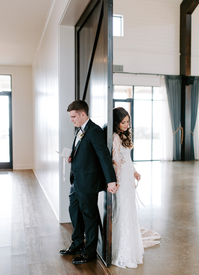 The bride and groom holding hands as they do their first touch.