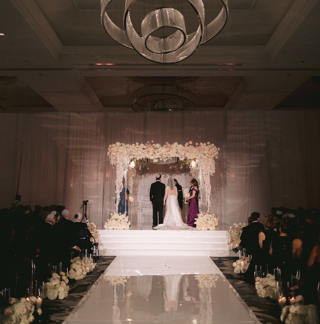 The bride and groom holding hands under the altar at their ceremony.