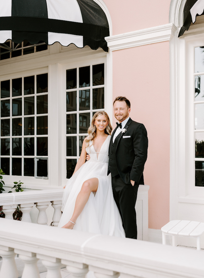 The bride and groom smiling on a balcony at the Grand Galvez.