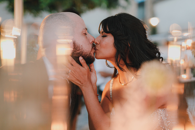 The bride and groom kissing during their wedding in the Tuscan countryside.