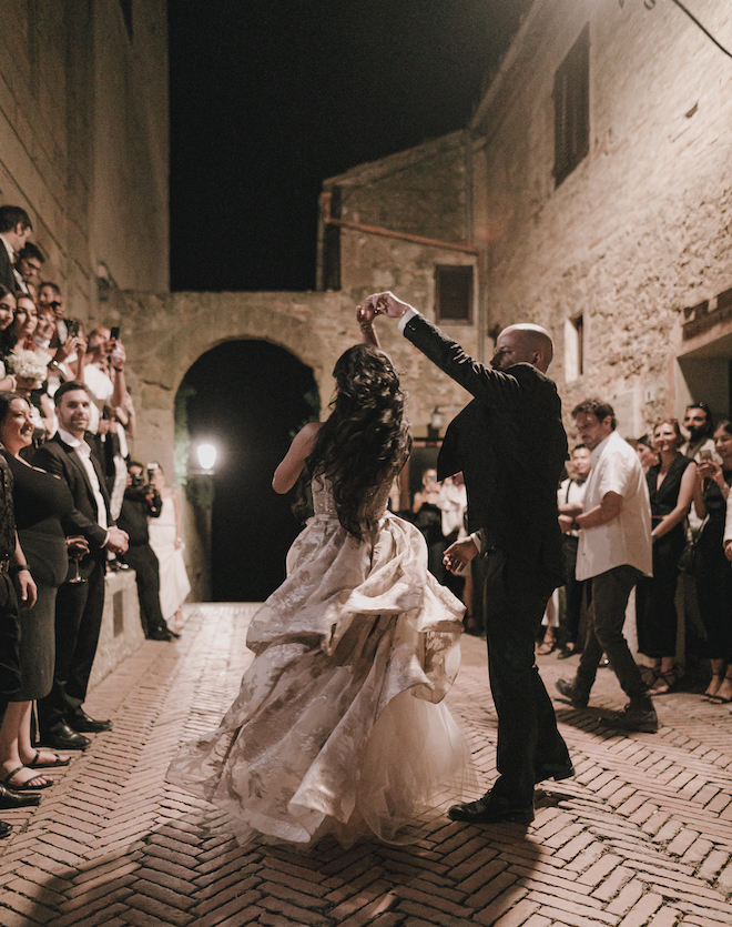 The bride and groom dancing as their guests watch.