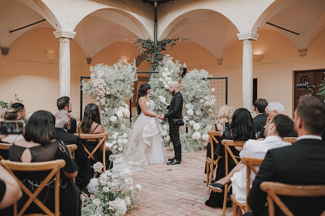 The bride and groom holding hands during their intimate wedding ceremony.