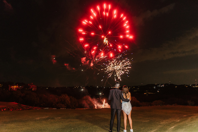 The bride and groom watching a fireworks show.