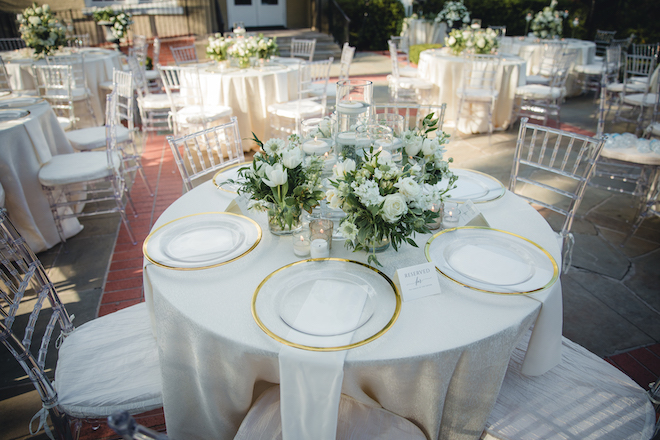 white round tables with green and white floral centerpieces.