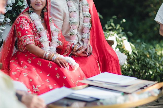 The bride and groom holding hands during their Nikkah ceremony. 