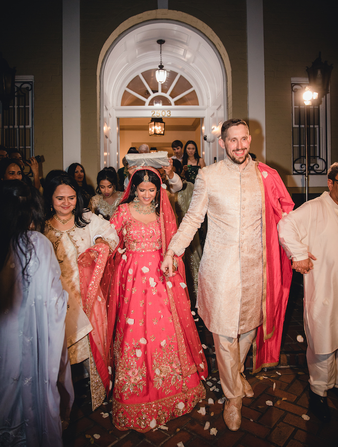 The bride and groom holding hands during their send off.