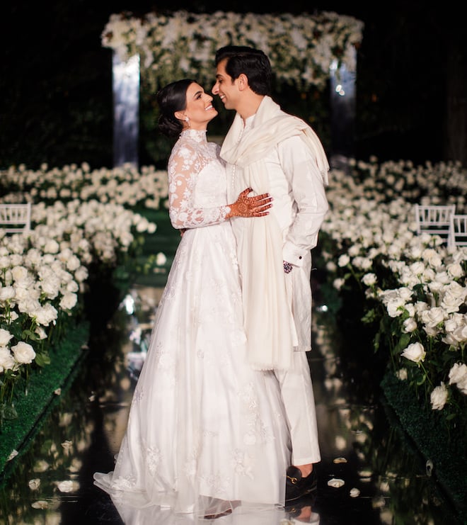 The bride and groom smile at each other at their backyard garden ceremony.