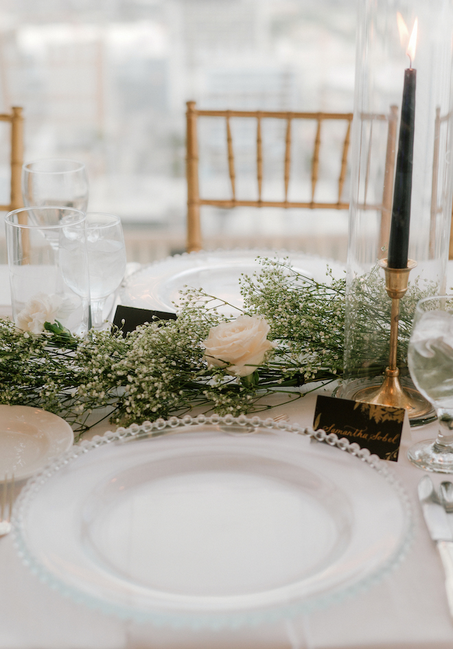 The table setting with candles and florals at the sophisticated wedding at the Petroleum Club of Houston.