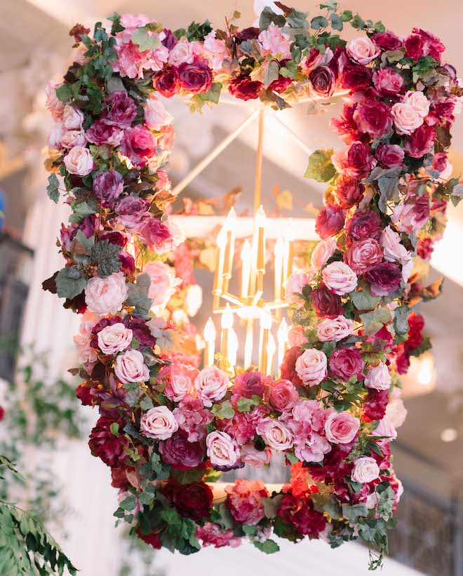 Wine-inspired florals covering the chandeliers at a luxurious Houston wedding.