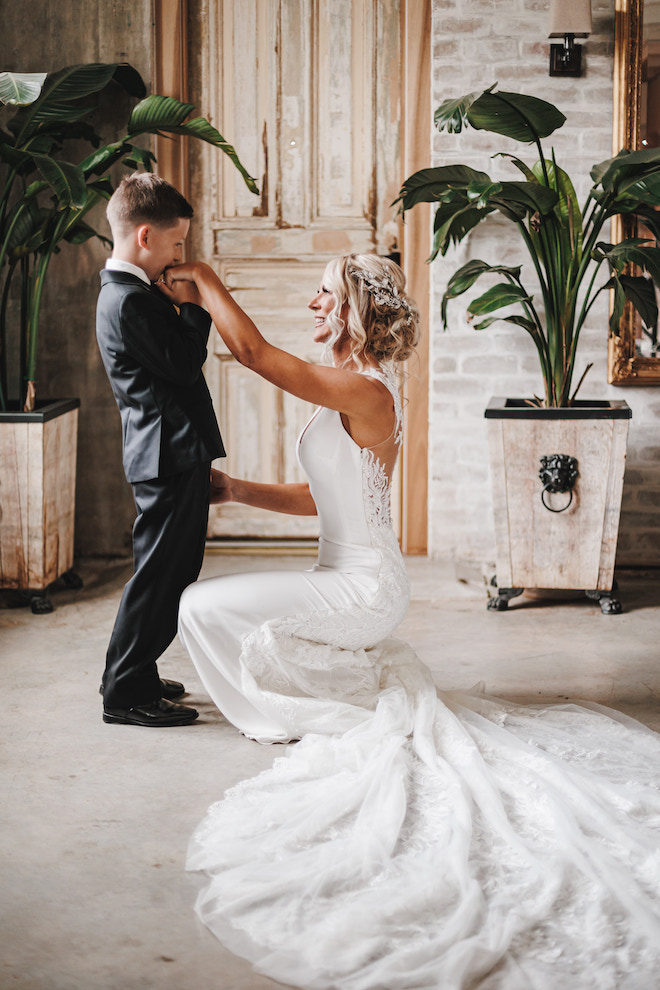 The bride's son kissing the bride's hand.