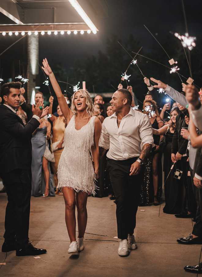 The bride and groom holding hands during their sparkler send off.