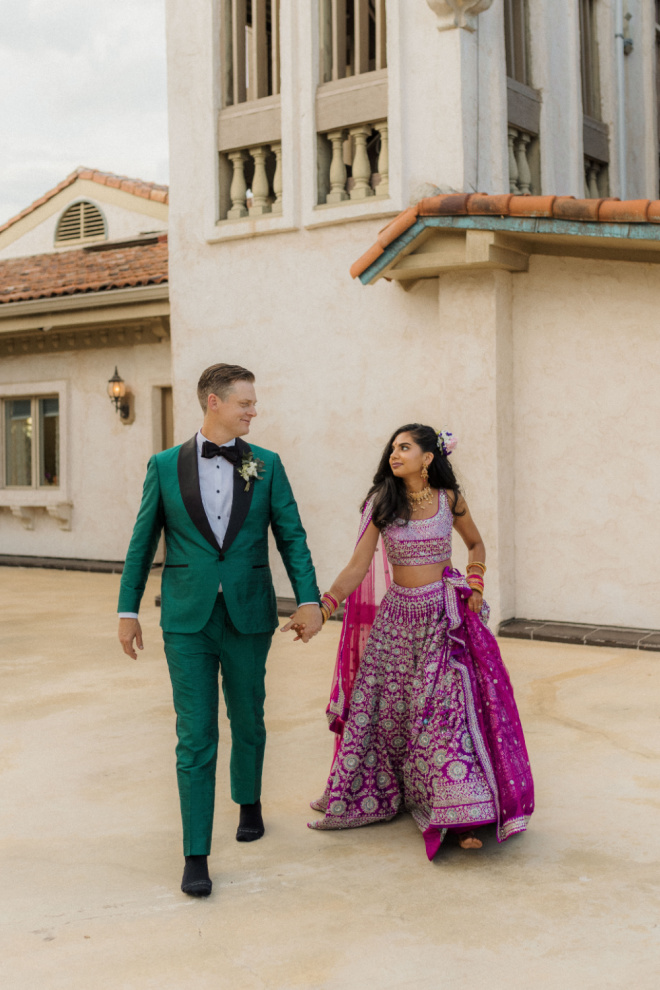 The bride and groom hold hands as they walk outside their wedding venue in Austin, Texas. 