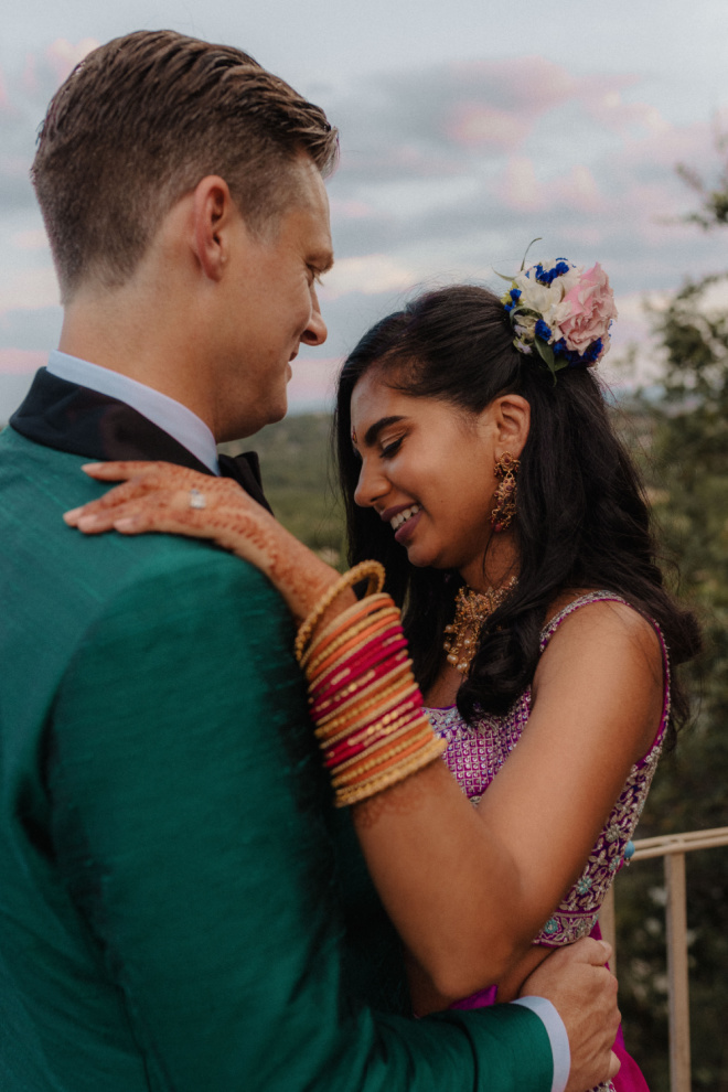 The bride and groom share an intimate moment on the balcony overlooking the rolling hills in Austin, Texas. 