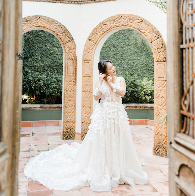 The bride putting on her earrings before her fall wedding.