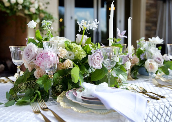 Fine china, pastel florals and candles decorate the table space for the secret garden wedding editorial. 