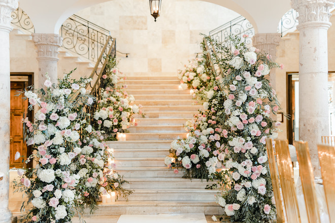 The grand staircase at the Bell Tower on 34th covered in pink hued florals.