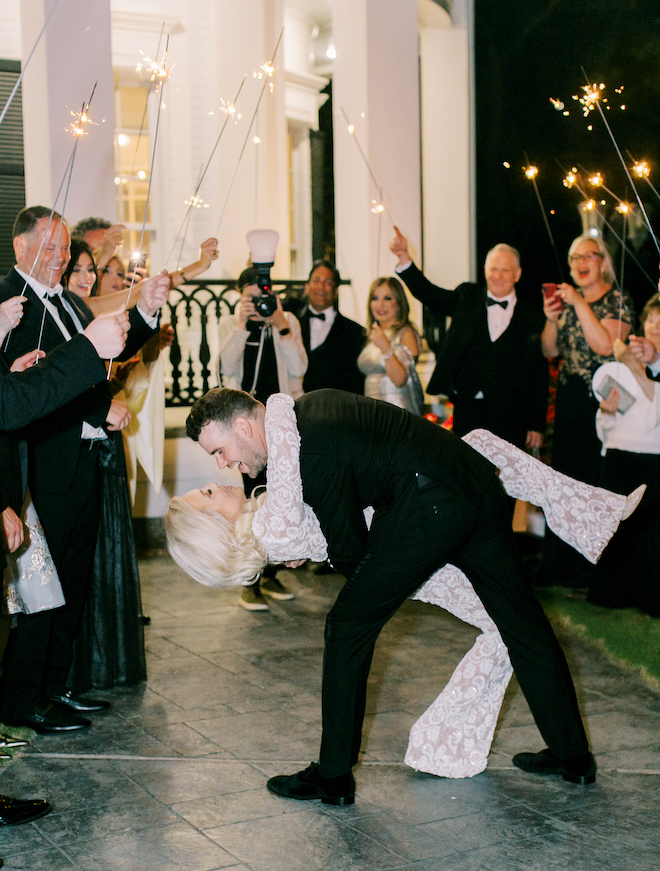 The groom dipping the bride during their sparkler send-off.