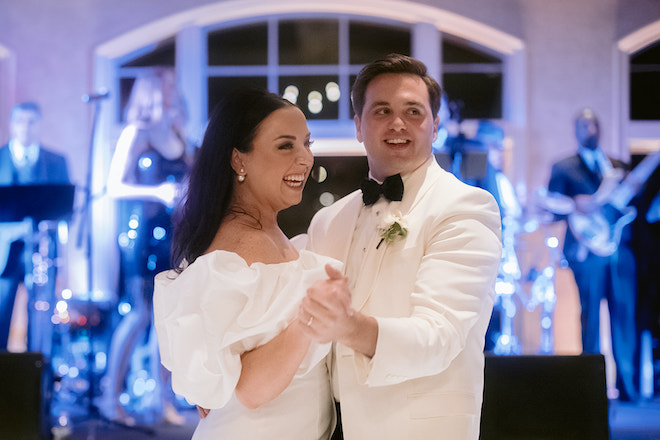 The bride and groom laughing as they dance.